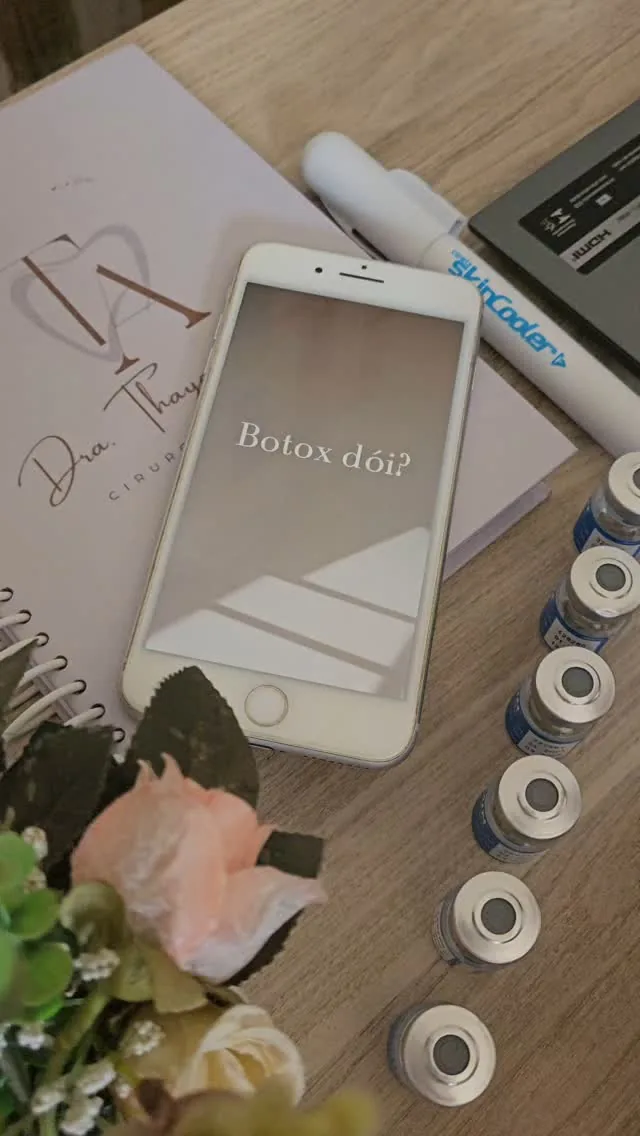 Mesa de trabalho com seringas, celular exibindo o texto 'Botox day' e fichas